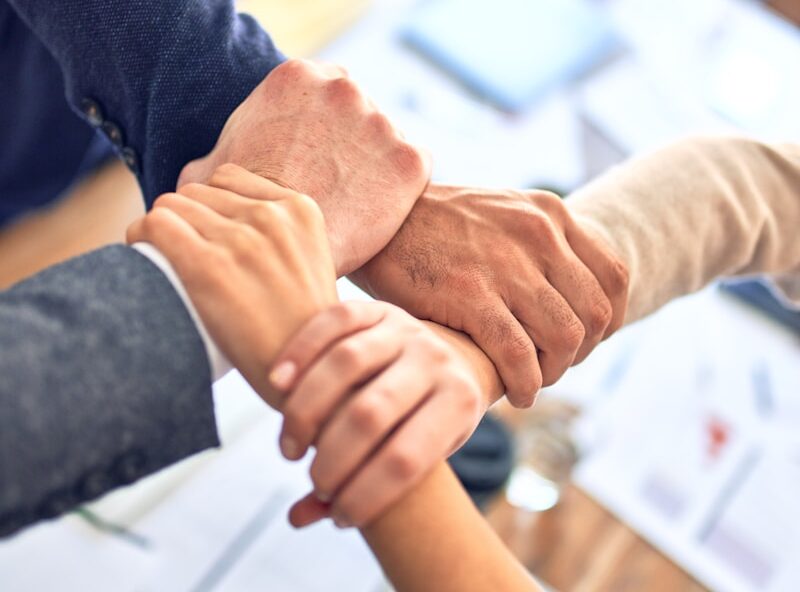 person in black long sleeve shirt holding persons hand